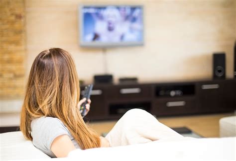 Premium Photo | Young woman watching tv in the room
