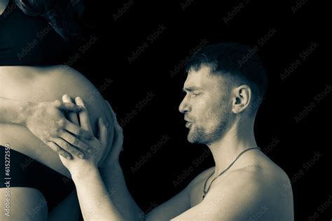 Side View Of Father Excitedly Communicating With Baby In Pregnant