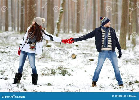 Beautiful Young Couple Walking In Snowy Winter Forest Stock Photo