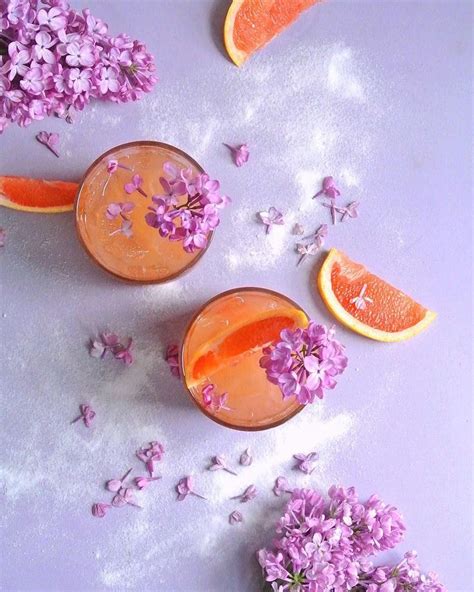 Three Glasses Filled With Orange Juice And Flowers