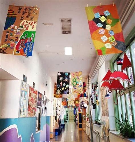 There Are Many Colorful Flags Hanging From The Ceiling In This School