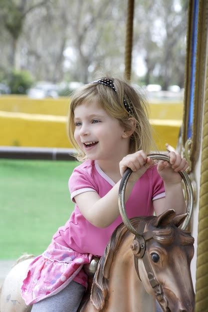 Petite Fille Blonde Jouant Des Chevaux Joyeux Aller Autour Photo Premium