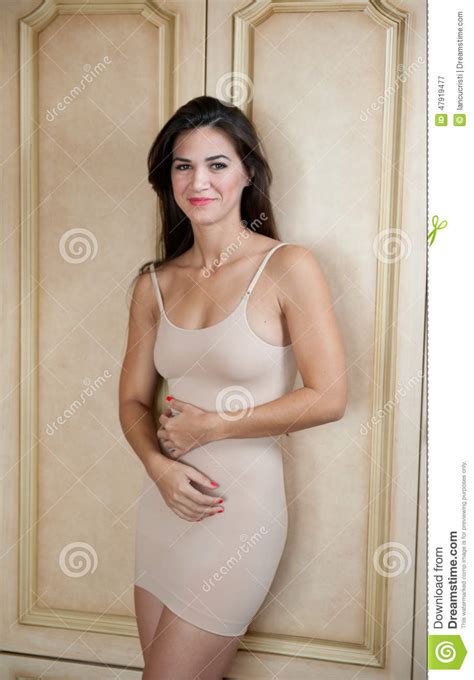 Mulher Moreno Nova Encantador No Vestido Curto Do Nude Do Ajuste Apertado Que Inclina Se Contra