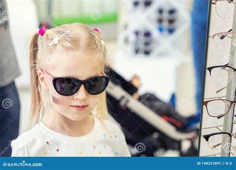 Petite Jeune Fille Blonde Caucasienne Mignonne Essayant Et Choisissant Des Lunettes De Soleil