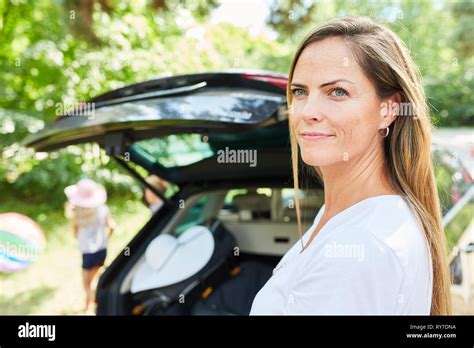 Woman Is About To Leave On Summer Car With Open Trunk Stock Photo Alamy