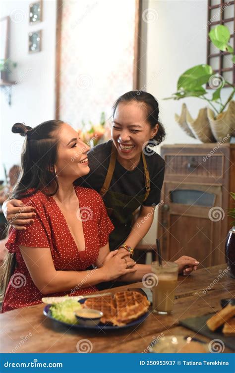 Young Vietnamese Waitress Smile And Hug A Friend Customer Stock Image