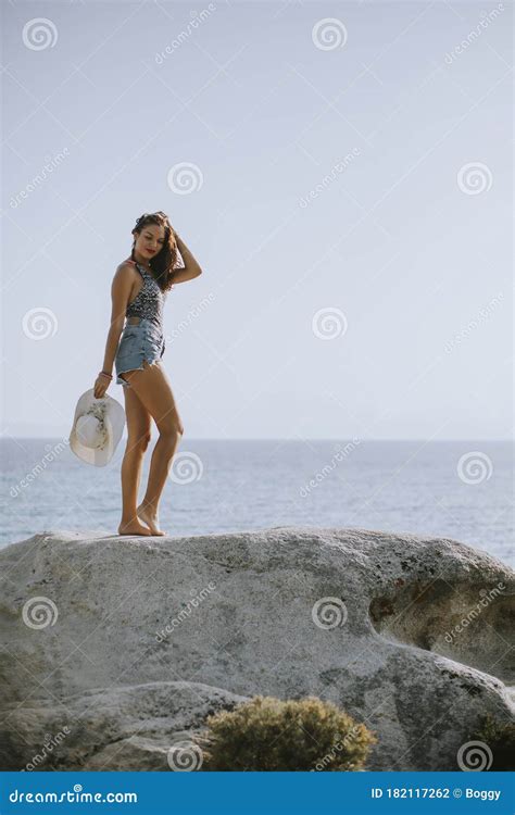 Junge Frau Im Bikini Auf Stein Durch Das Meer Steht Stockfoto Bild Von Draussen Bikini