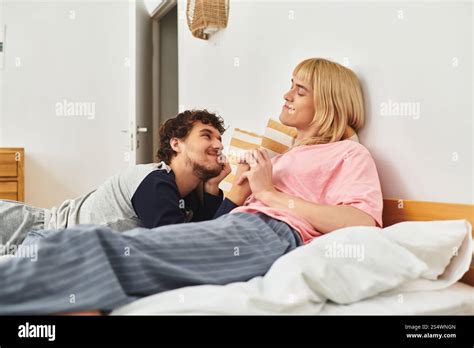 Two Gay Men Share A Tender Moment In Their Serene Bedroom Expressing Deep Affection And Joy