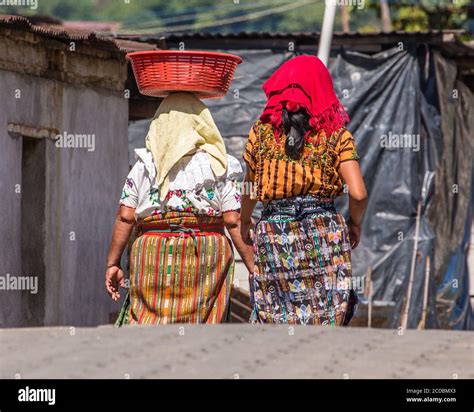 Two Tzutujil Mayan Woman In Traditional Dress Walking On The Street In