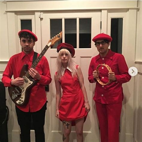 Three People In Red Outfits Are Holding Guitars And Posing For The