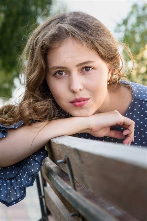 Une Fille Brunette Assise Sur Un Banc Dans La Ville Portrait D Une Fille En Robe Bleue Avec Des