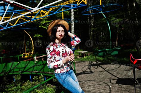 Portrait Of Brunette Girl In Pink Glasses And Hat With Ice Cream At Amusement Park