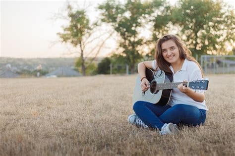 Premium Photo | Young smiling girl singing at guitar