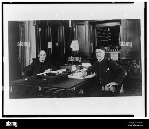 Two Treasury Department Employees Seated At Desk In Office Stock Photo