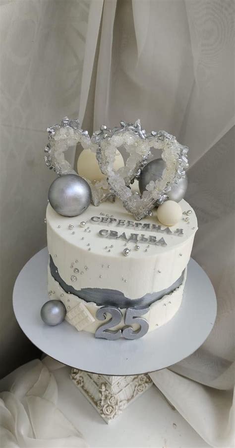 A White Cake With Silver Decorations On Top