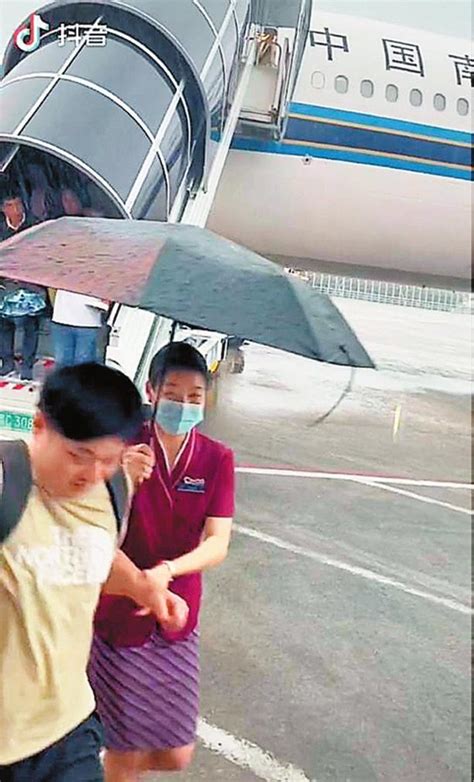 台风暴雨中，深圳机场上演暖心一幕 空姐冒雨撑伞护送旅客上摆渡车坪山新闻网