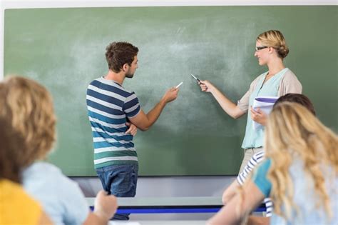 Premium Photo | Student and teacher pointing at blackboard