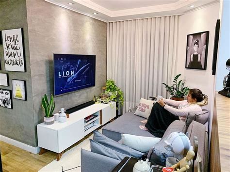 A Woman Sitting On A Couch In Front Of A Flat Screen Tv