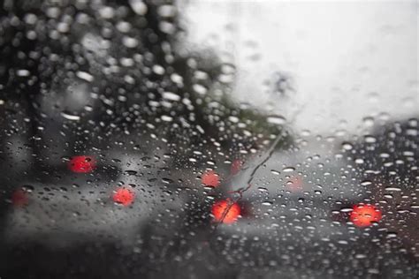 Drops Of Rain Drizzle On The Glass Windshield In The Evening Street In