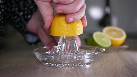 Squeeze the juice of a lemon close-up with a glass squeezer 20389452 ...