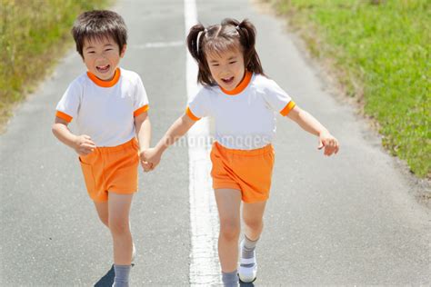 手をつないで走る2人の幼稚園児の写真素材 [fyi01573213] ストックフォトの Qlean Market