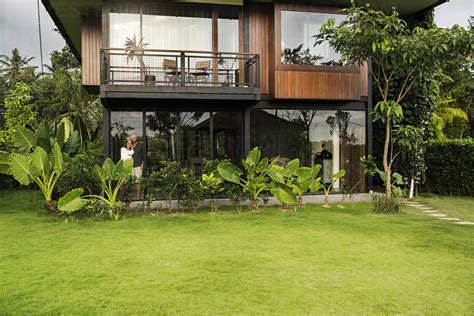 Garden View Of Couple Standing In Modern Design House Surrounded By