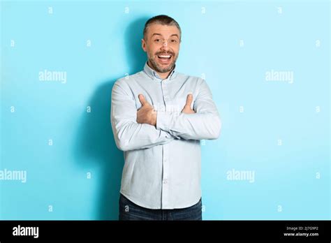 Mature Man Smiling To Camera Standing Over Blue Studio Background Stock Photo Alamy