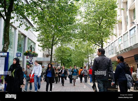 People Walking Down New Street A Pedestrian Street With Many Shops