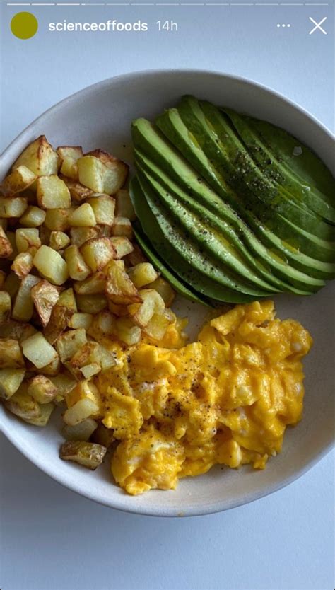 A White Plate Topped With Eggs Potatoes And Cucumbers