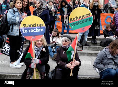 Two Women Hold Placards Reading Stand Up To Racism Refugees Welcome