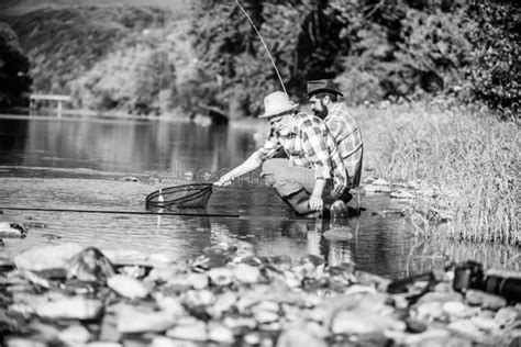Rural Getaway Retired Dad And Mature Bearded Son Two Male Friends Fishing Together Stock Photo