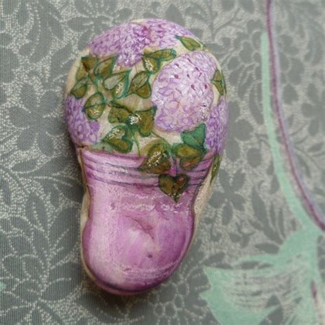 A Purple Vase Sitting On Top Of A Table Next To A Flowery Wallpaper