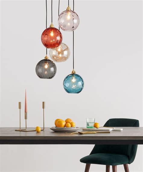 An Image Of A Dining Room Setting With Hanging Lights And Fruit On The