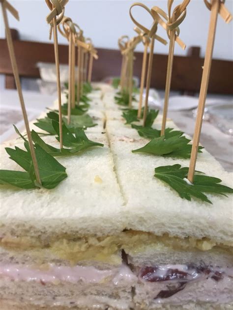 A Sandwich With Toothpicks Sticking Out Of It S Sides And Green Leafy