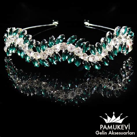 A Tiara With Green And Clear Crystal Stones On It S Headpieces