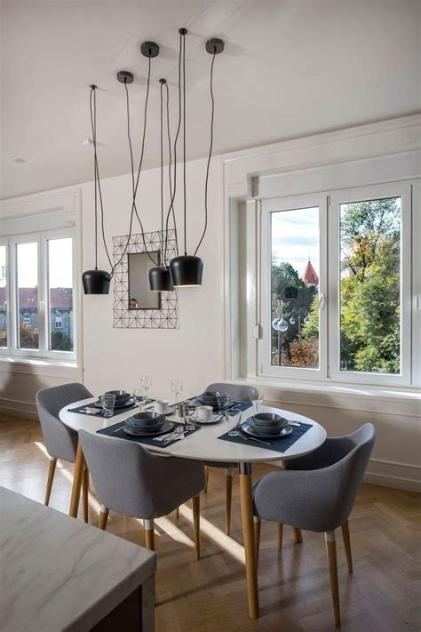 a dining room table with chairs and plates on it in front of two large ...