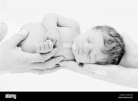 A Black And White Photograph Of A Newborn Caucasian Male Baby Being