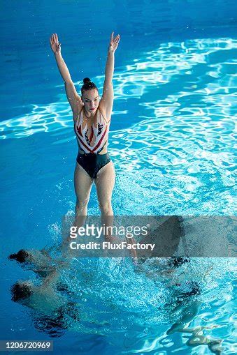 Woman Jumping Out Of The Water During A Synchronized Swimming