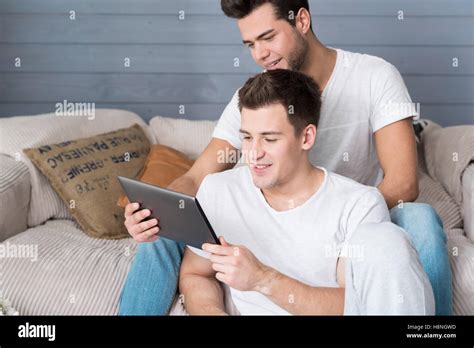 Relaxed Gay Couple Resting On The Sofa And Using Tablet Stock Photo Alamy