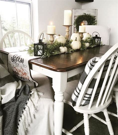 A Dining Room Table With Candles And Greenery On It Surrounded By