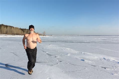Man In A Cap With A Naked Torso Running Across The Ice Of A Frozen River Stock Photo Image Of