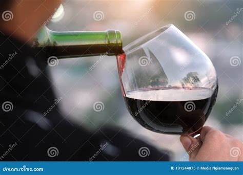 Hand Pouring Glass Of Wine