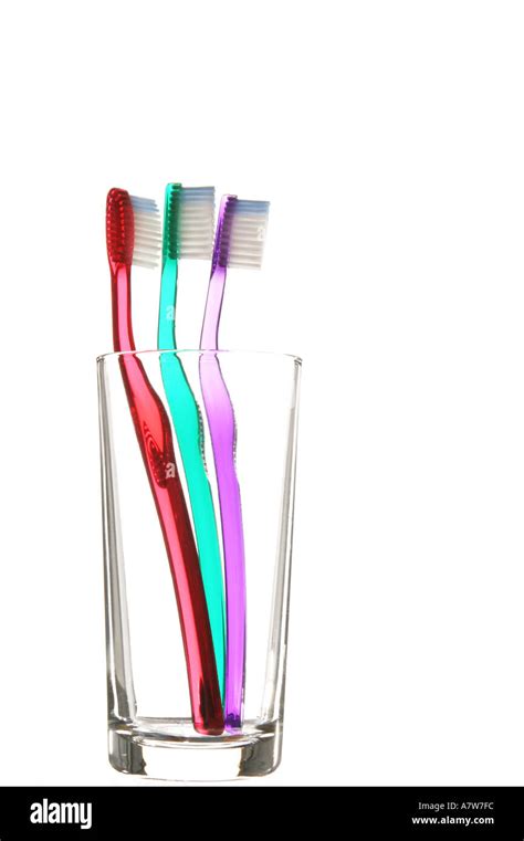 Clear Coloured Toothbrushes In A Clear Glass With A Bright White