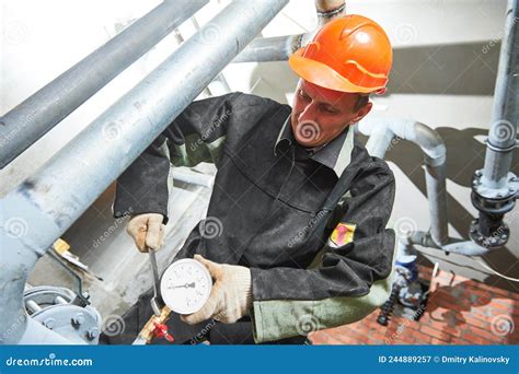 Plumber Technician Works With Water Pressure Meter In Boiler Room Stock