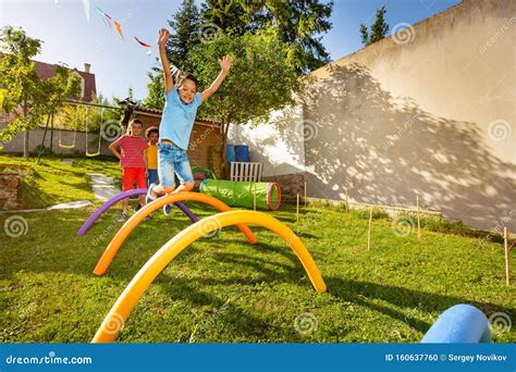 Juego De Razas Con ObstÃculos NiÃos Saltan Sobre La Barrera Foto de