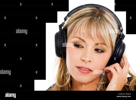 Jeune fille blonde à l écoute de la musique sur son casque antibruit isolé sur fond blanc Photo