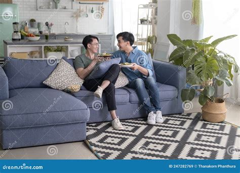 Pareja Gay Joven Sonriente Teniendo Comida Saludable En La Sala De Estar En Casa Lgbtq Y
