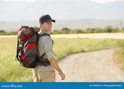 Homme Avec Le Sac à Dos Marchant Sur La Route De Campagne Photos stock