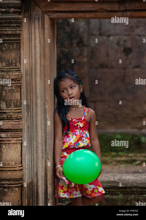 Cambodian Little Girl With A Green Balloon In Banteay Srei Temple Gate