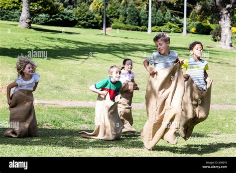 Children Having A Sack Race In Park Stock Photo Alamy